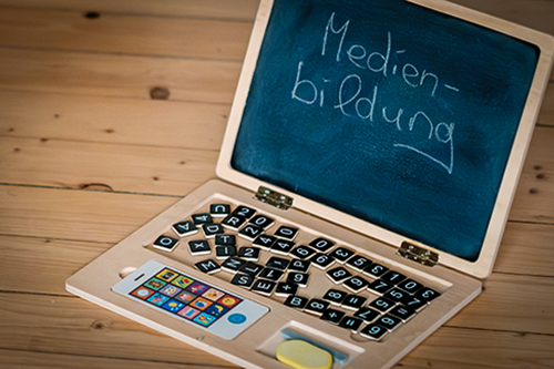 Kinder-Laptop aus Holz mit Tafel und dem Wort Medienbildung